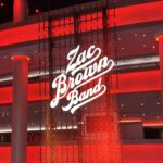 Zac Brown Band logo in a red-lit, multi-story, large room with a stage and many