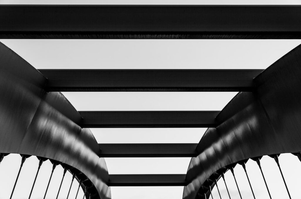 Greyscale photograph of metal bridge architecture