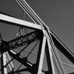 A metal bridge's framework is seen from below, with its metal beams and